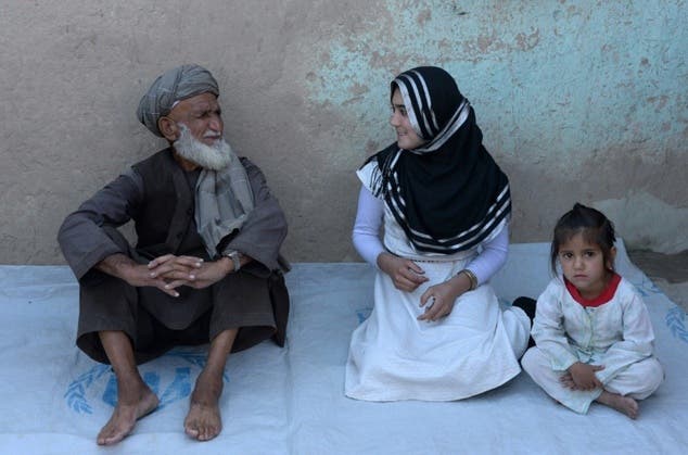 Aziza Rahimzada, (C), who has been nominated for the International Children's Peace Prize, speaks with her father Jandad Rahimzada at a refugee camp in Kabul