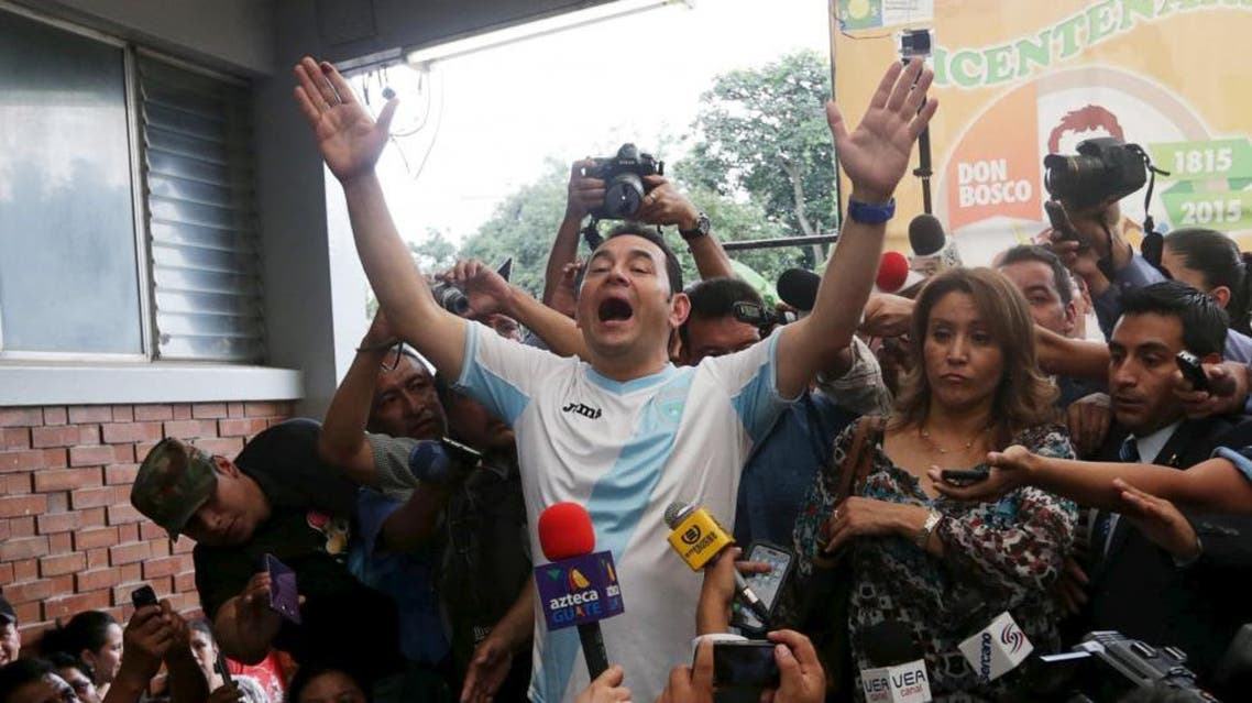 Jimmy Morales (C), presidential candidate for the National Convergence Front party (FCN), gestures while addressing the media next to his wife Gilda Marroquin (R) after casting his vote at a polling station in Guatemala City. (Reuters)