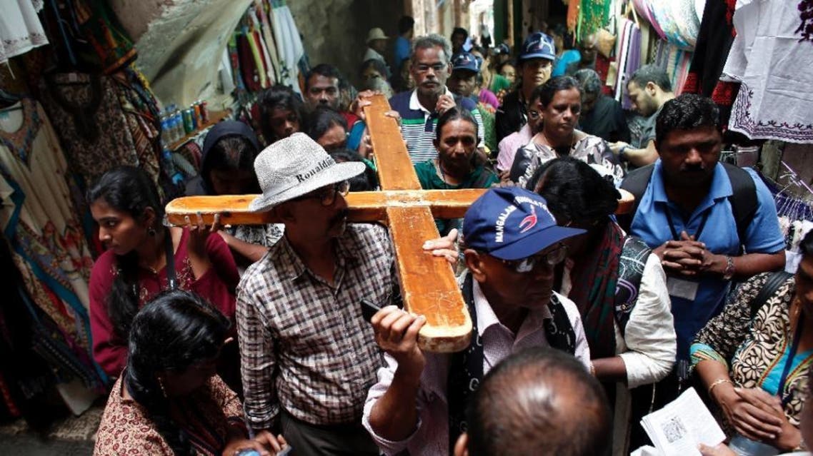 A small group of Christian pilgrims carry a cross in the Via Dolorosa street deserted by tourists in the Jerusalem's Old City, on October 23, 2015 (AFP)