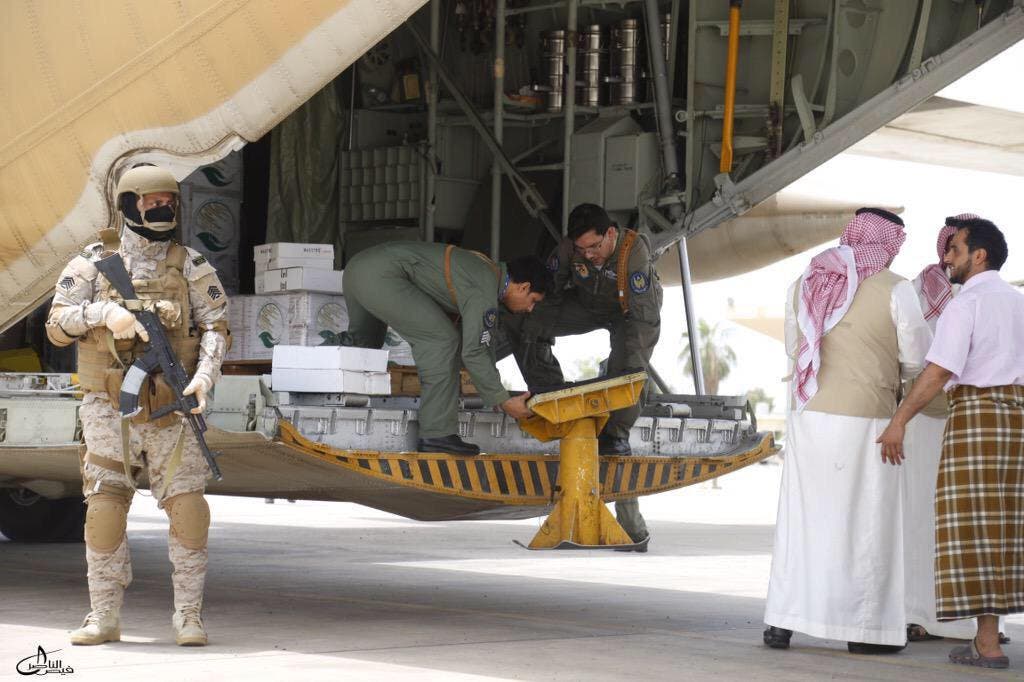 A Saudi soldier stands guard as servicemen on a Saudi military cargo plane prepare to unload aid at the international airport of Yemen's southern port city of Aden. (Reuters)