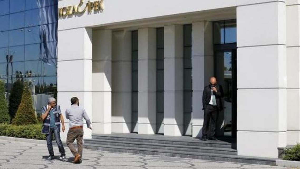 Two plainclothes police officers leave an office of Koza Ipek Group in Ankara, Turkey, September 1, 2015, as a company official stands at the entrance during a police raid. (Reuters)