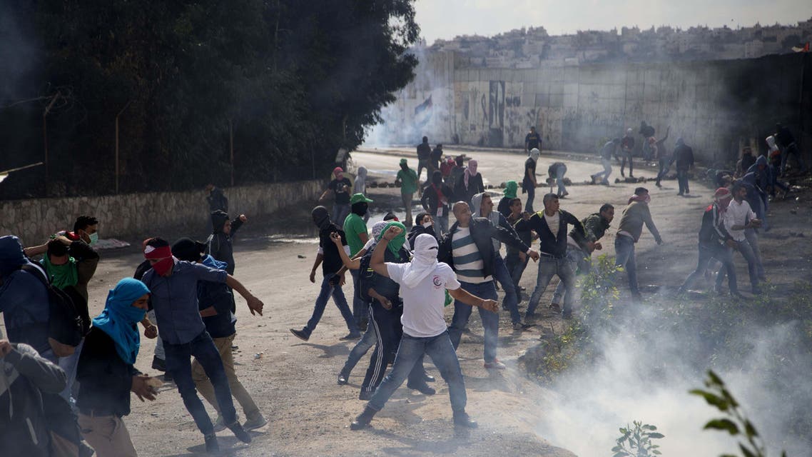 Palestinian students hurl stones at Israeli troops over the separation barrier during clashes following a protest near the Al-Quds University in the West Bank village of Abu Dis, near Jerusalem, Wednesday, Oct. 28, 2015. (APP)