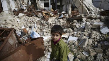 A boy walks amid damaged buildings in the town of Douma, eastern Ghouta in Damascus. (Reuters)