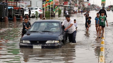 AP - Iraqis push a car, submerged in water, as others make their way through a flooded street after heavy rain fell in Baghdad, Iraq, Thursday, Oct. 29, 2015. 