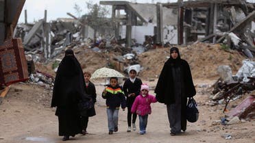 Palestinians walk near the ruins of houses that witnesses said were destroyed or damaged by Israeli shelling during a 50-day war last summer, on a winter day east of Gaza City February 20, 2015. (Reuters)