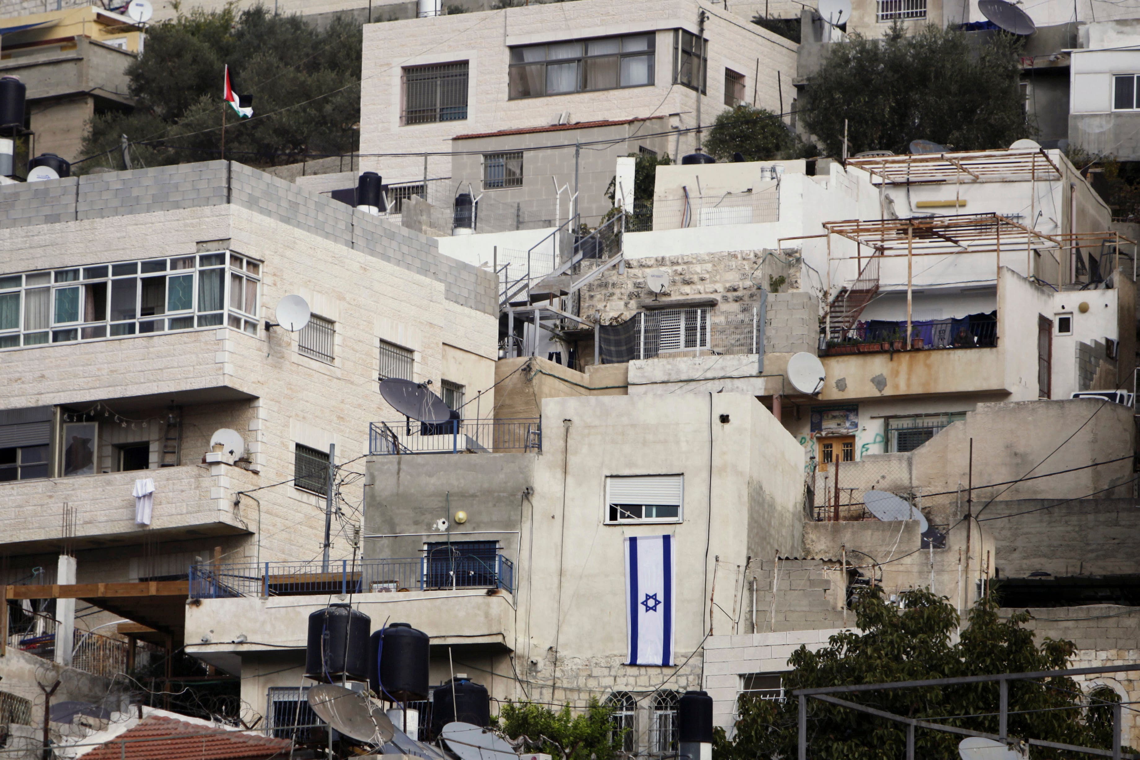  In this Monday, Oct. 19, 2015, photo, an Israeli flag hangs on the wall of a building that was taken over by Israeli settlers after Palestinian families were evicted in the Silwan neighborhood of east Jerusalem. (AP)