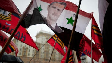 Pro-Kremlin youths hold a Syrian flag bearing a portrait of Syrian President Bashar al-Assad during a picket in protest against American policy in front of the U.S. Embassy in Moscow, Russia, Friday, April 3, 2015.  (AP)