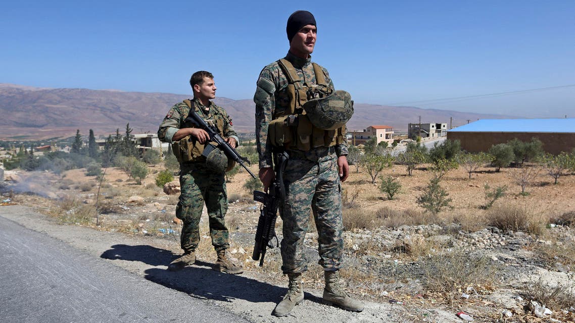 FILE - In this Aug. 4, 2014, file photo, Lebanese army soldiers stand guard at an entrance to Arsal, a predominantly Sunni Muslim town near the Syrian border in eastern Lebanon. Attackers blew up a roadside bomb near an army patrol near the Syrian border Friday, Sept. 19, 2014 killing two soldiers and wounding many in the latest spillover from the civil war next door, security official said. (AP Photo/Bilal Hussein, File)
