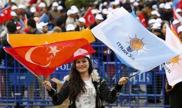 A supporter of the ruling AK Party waves national and party flags during an election rally in Ankara, Turkey, October 31, 2015.