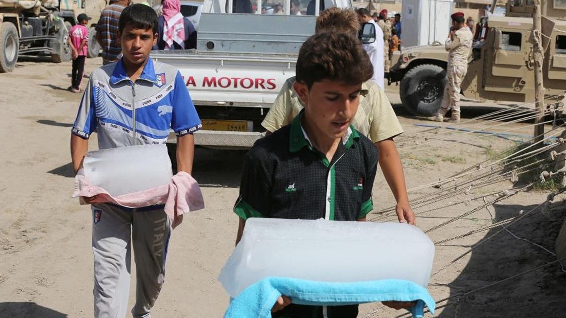Internally displaced Iraqis carry ice at a camp near the Bzebiz bridge, 40 miles (65 kilometers) west of Baghdad, Iraq, Friday, Sept. 25, 2015. ap
