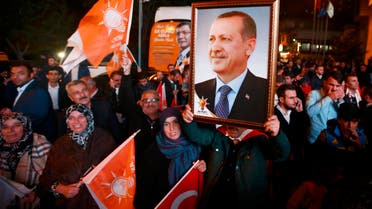 People wave flags and hold a portrait of Turkish President Tayyip Erdogan outside the AK Party headquarters in Istanbul, Turkey November 1, 2015. T