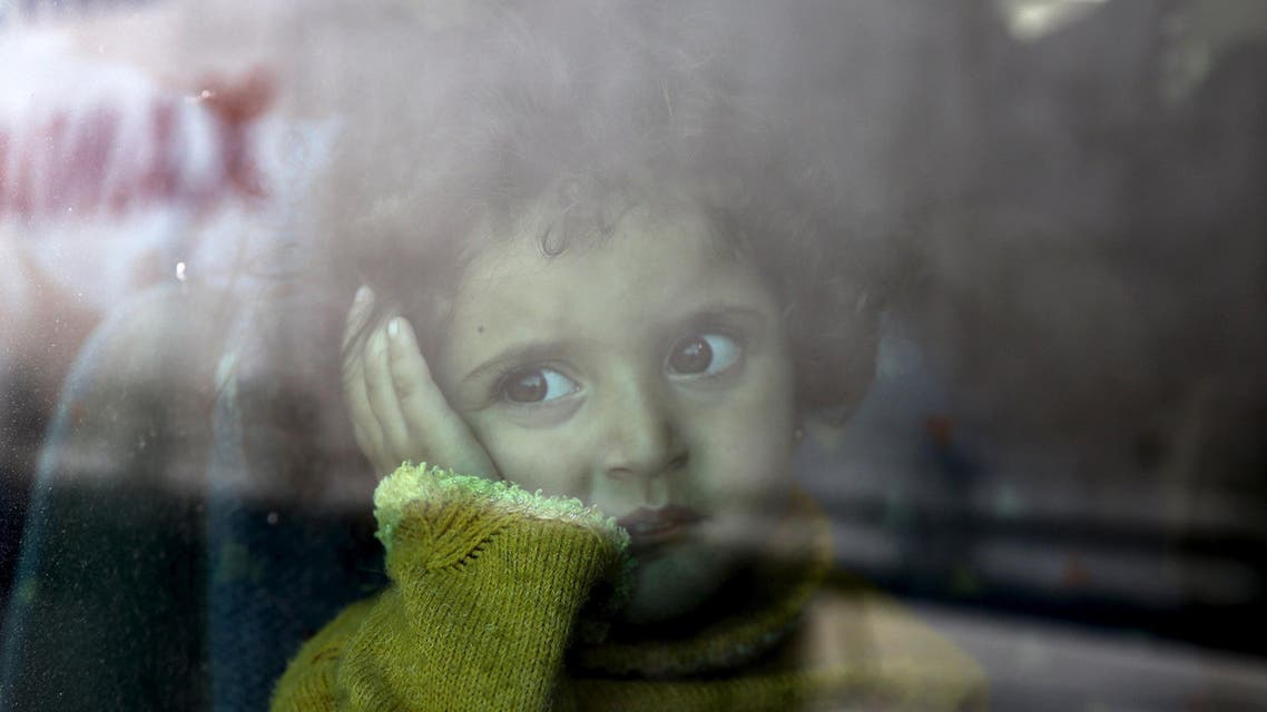 Syrian child is seen inside a bus following her arrival by the Eleftherios Venizelos passenger ferry with over 2,500 migrants and refugees from the island of Lesbos at the port of Piraeus, near Athens, Greece, October 8, 2015. REUTERAS