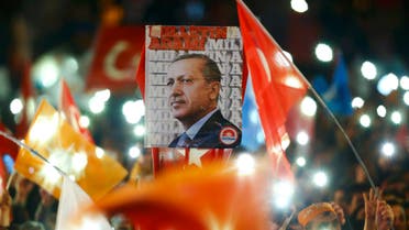 People wave flags and hold a portrait of Turkish President Tayyip Erdogan as they wait for the arrival of Prime Minister Ahmet Davutoglu in Ankara, Turkey November 2, 2015.
