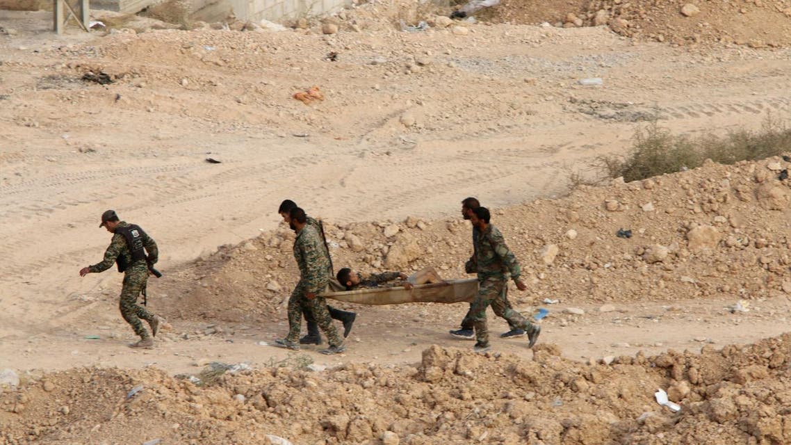 Syrian soldiers carry a wounded comrade on a stretcher in Harasta, northeast of Damascus, Syria, Thursday, Oct. 22, 20115. Syrian troops have been fighting rebels in the frontline district, which lies on the northeastern edge of Damascus and only few kilometers (miles) from the presidential palace, since 2013. Neither side has been able to make a breakthrough in the fighting, although state media has reported Syrian army advances in the last week as part of a major army offensive.(Alexander Kots/Komsomolskaya Pravda via AP)
