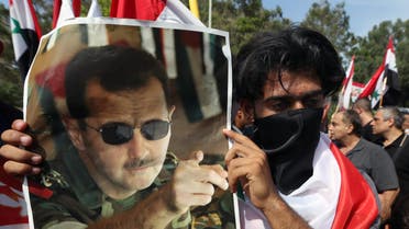  A Syrian who lives in Lebanon holds a photo of Syrian President Bashar Assad, during a rally to thank Moscow for its intervention in Syria, in front of the Russian embassy in Beirut, Lebanon, Sunday, Oct. 18, 2015. (AP Photo/Bilal Hussein)