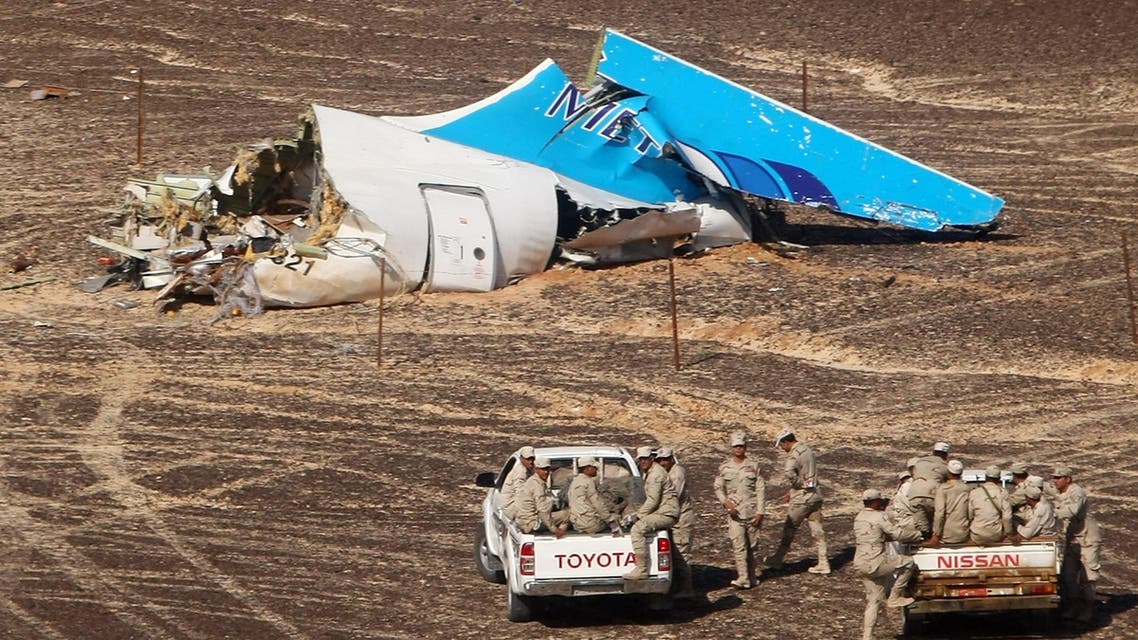 In this photo made available Monday, Nov. 2, 2015, and provided by Russian Emergency Situations Ministry, Egyptian Military on cars approach a plane's tail at the wreckage of a passenger jet bound for St. Petersburg in Russia that crashed in Hassana, Egypt, on Sunday, Nov. 1, 2015. The Russian cargo plane on Monday brought the first bodies of Russian victims killed in a plane crash in Egypt home to St. Petersburg, a city awash in grief for its missing residents. (Maxim Grigoriev/Russian Ministry for Emergency Situations via AP)