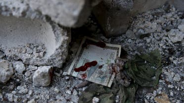 A blood stained Syrian banknote is pictured at a site hit by missiles fired by government forces towards a busy marketplace in the Douma neighborhood of Damascus, Syria October 30, 2015. At least 40 people were killed and about 100 wounded after Syrian government forces fired missiles into the market place in a town near Damascus, a conflict monitor and a local rescue group said on Friday. REUTERS/Bassam Khabieh