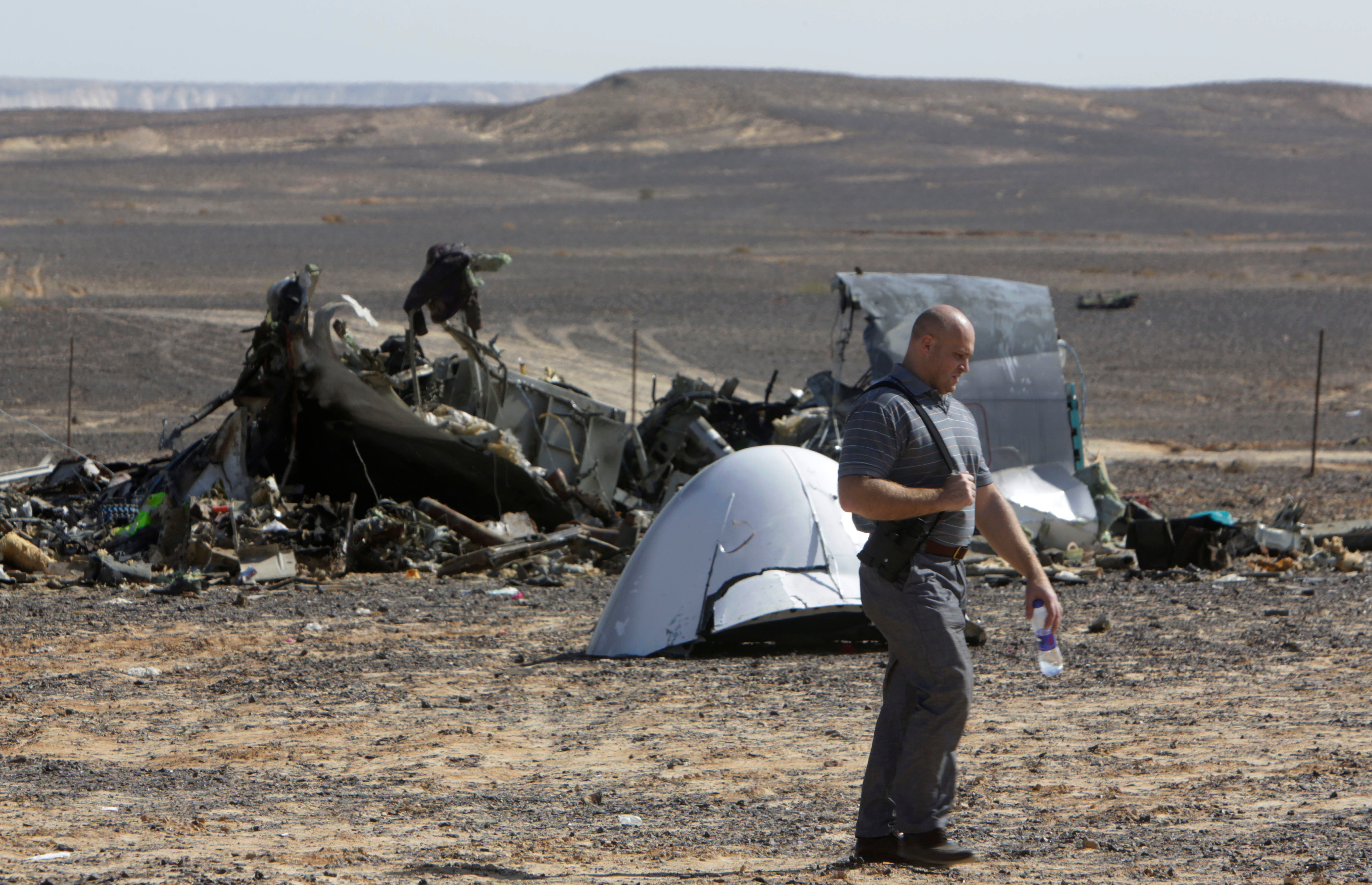 A Russian investigator walks near wreckage a day after a passenger jet bound for St. Petersburg, Russia, crashed in Hassana, Egypt, on Sunday, Nov. 1, 2015.  (AP)