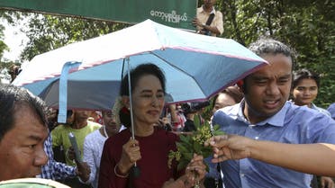 Myanmar pro-democracy leader Aung San Suu Kyi accepts flowers from supporters as she visits polling stations at her constituency town Kawhmu township November 8, 2015. REUTERS