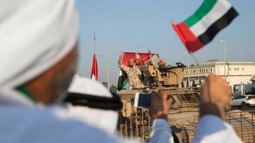 In this photo made available by the Emirates News Agency, WAM, Emirati people wave the national flag as a convoy of UAE military vehicles and personnel travels from Al Hamra Military Base to Zayed Military City, marking the return of the first batch of UAE Armed Forces military personnel from Yemen, United Arab Emirates, Saturday, Nov. 7, 2015. (WAM/AP)