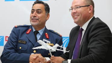 Hakan Buskhe, President and Chief Executive Officer of Saab, right, and UAE Major General Major General Abdullah Al Hashimi shake hands as they hold a model of the Bombardier Global 6000 aircraft during the second day of the Dubai Airshow in Dubai, United Arab Emirates, Monday, Nov. 9, 2015. 