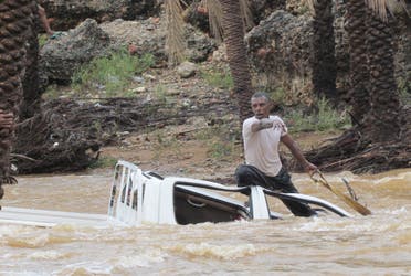 A man gestures as he tries to save a vehicle swept away by flood waters in Yemen's island of Socotra November 2, 2015.