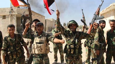 Syrian soldiers waving Syrian flags celebrate the capture of Achan, Hama province, Syria. (File: AP)
