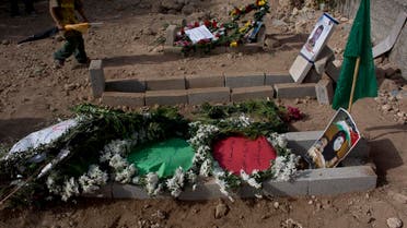 A Palestinian boy walks by the graves of Riham Dawabsheh, 27, front, her husband Saed Dawabsheh, center, and her 18-month-old son Ali, following her funeral procession in the West Bank village of Duma, near Nablus. (AP)