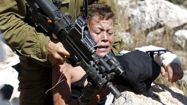 An Israeli soldier detains a Palestinian boy during a protest against Jewish settlements in the West Bank village of Nabi Saleh, near Ramallah August 28, 2015. (File photo: Reuters)
