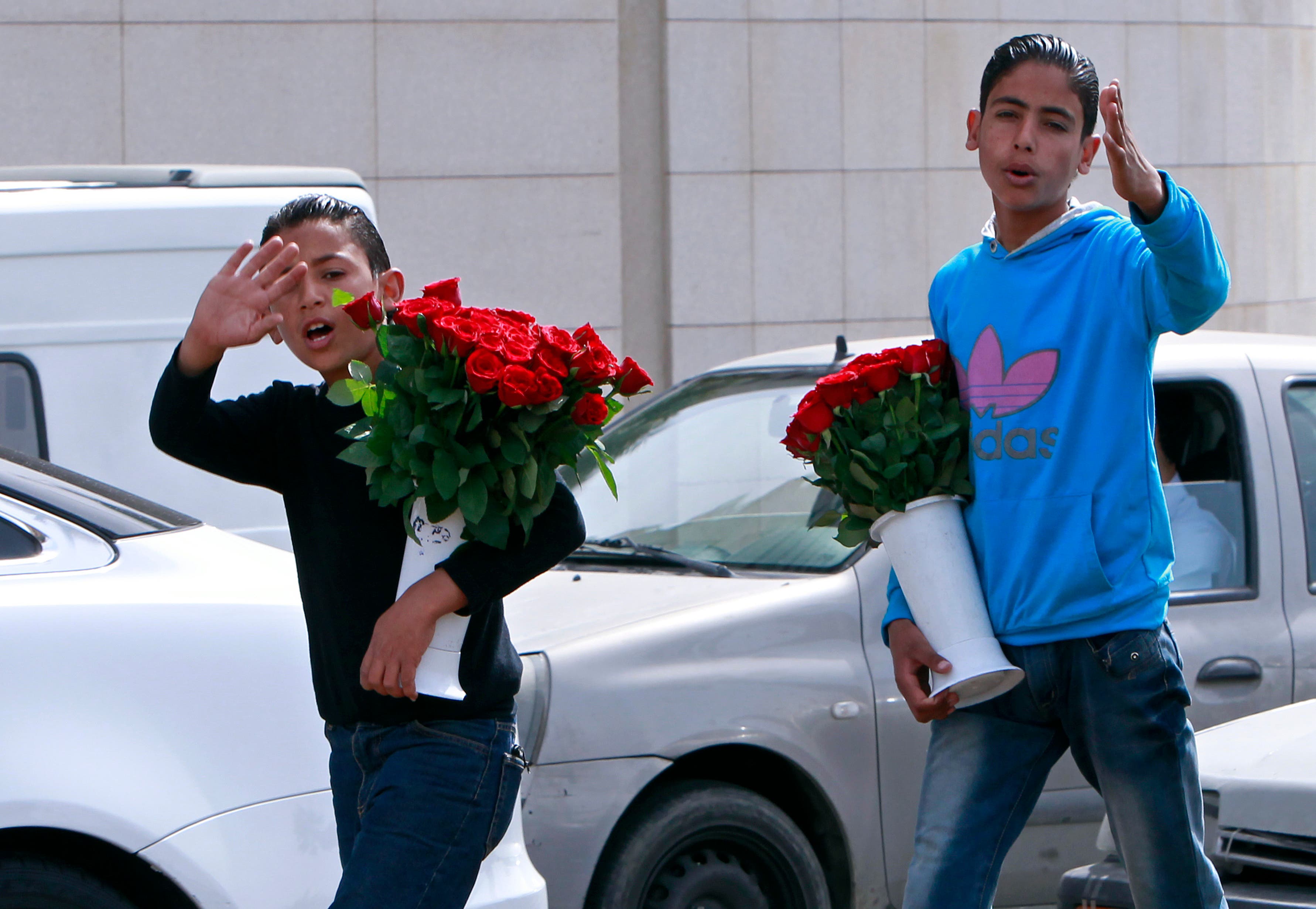 Two Syrian brothers Bashar, 12, left, and Rasem, 14, right, who fled their home from Hassakeh, try to sell flowers to make a living in Beirut, Lebanon, Wednesday, March 13, 2013. (AP)