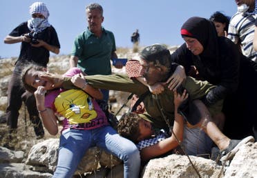 Palestinians scuffle with an Israeli soldier as they try to prevent him from detaining a boy during a protest against Jewish settlements in the West Bank village of Nabi Saleh, near Ramallah August 28, 2015. (Reuters) 