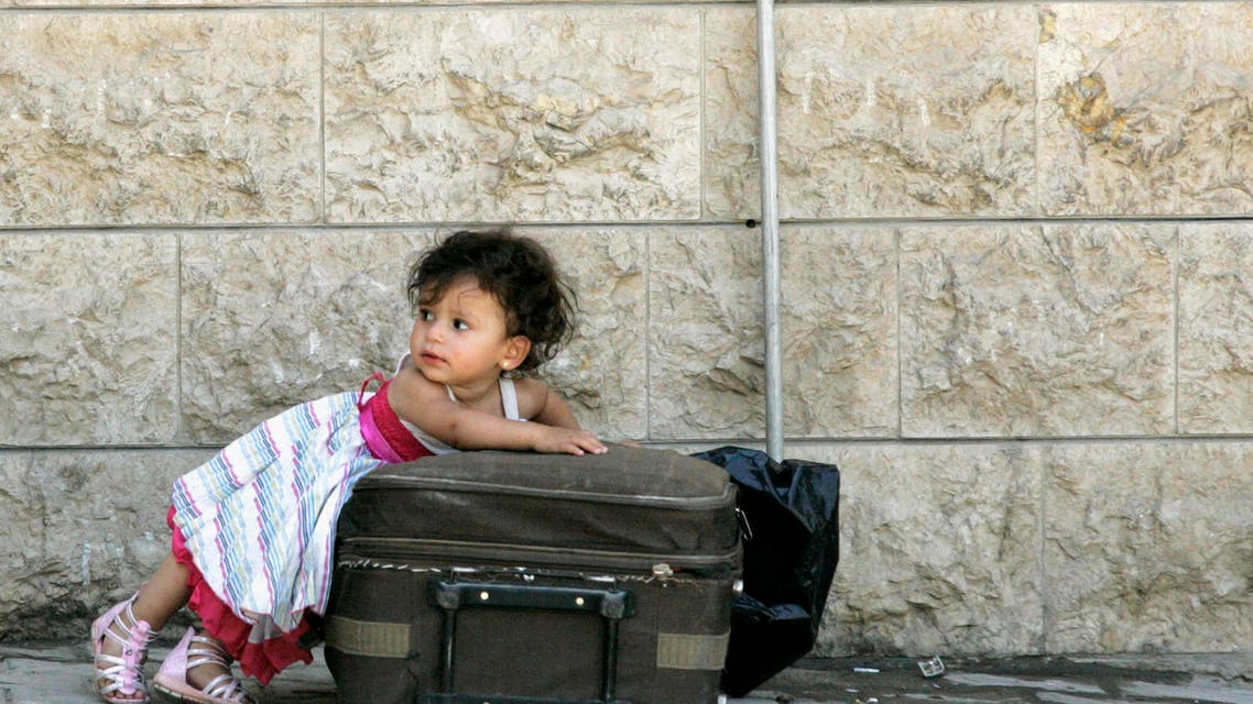 A Syrian girl leans over a suitcase on the Lebanese-Syrian border town of al-Masnaa July 20, 2012. (Reuters)