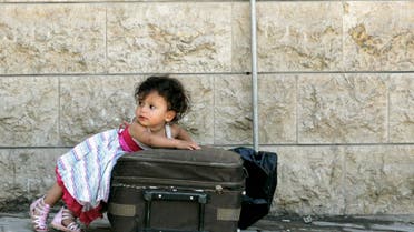 A Syrian girl leans over a suitcase on the Lebanese-Syrian border town of al-Masnaa July 20, 2012. (Reuters)