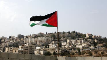 In this photo taken Tuesday, Oct. 20, 2015, a Palestinian flag flies on the roof of a temporary apartment that the Palestinian family family of Abu Nab has moved to, after being evicted from their apartment recently, in the Silwan neighborhood of east Jerusalem. AP