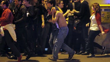 An injured man holds his head as people gather near the Bataclan concert hall following fatal shootings in Paris, France, November 13, 2015.  (Reuters)