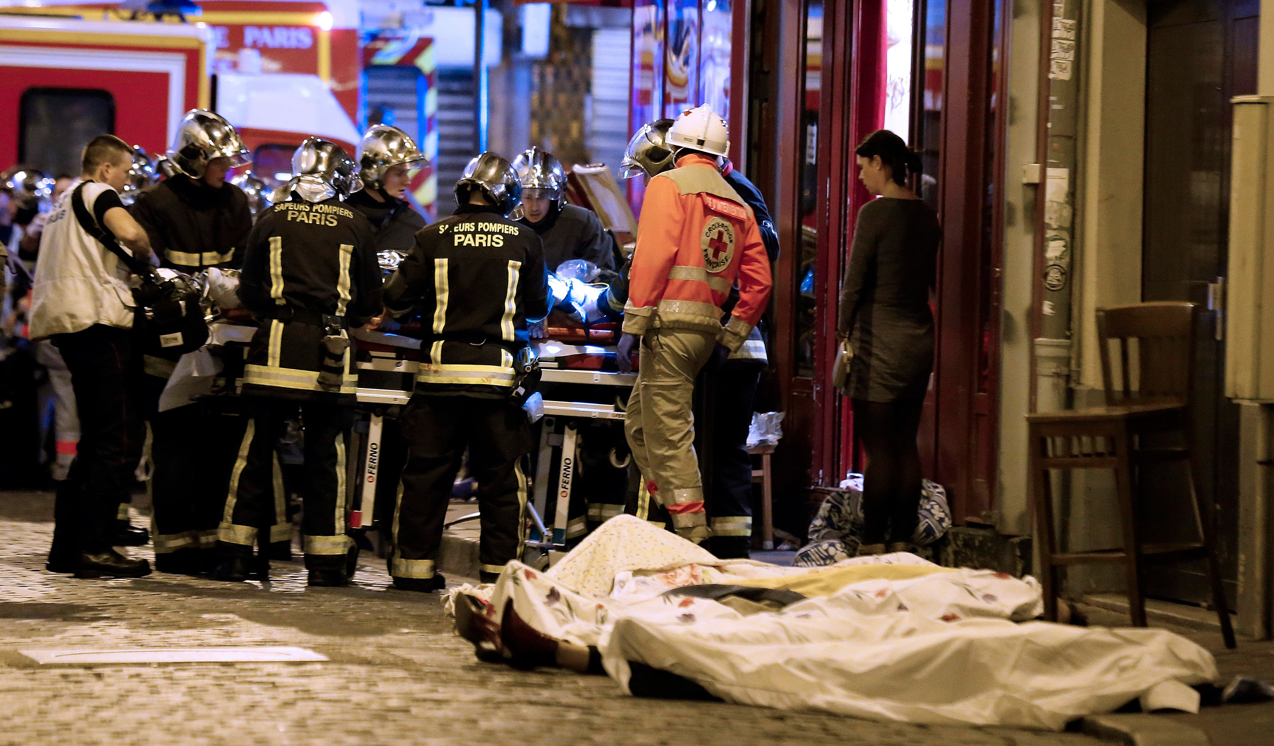 Rescue workers gather at victims in the 10th district of Paris, Friday, Nov. 13, 2015.  (AP)