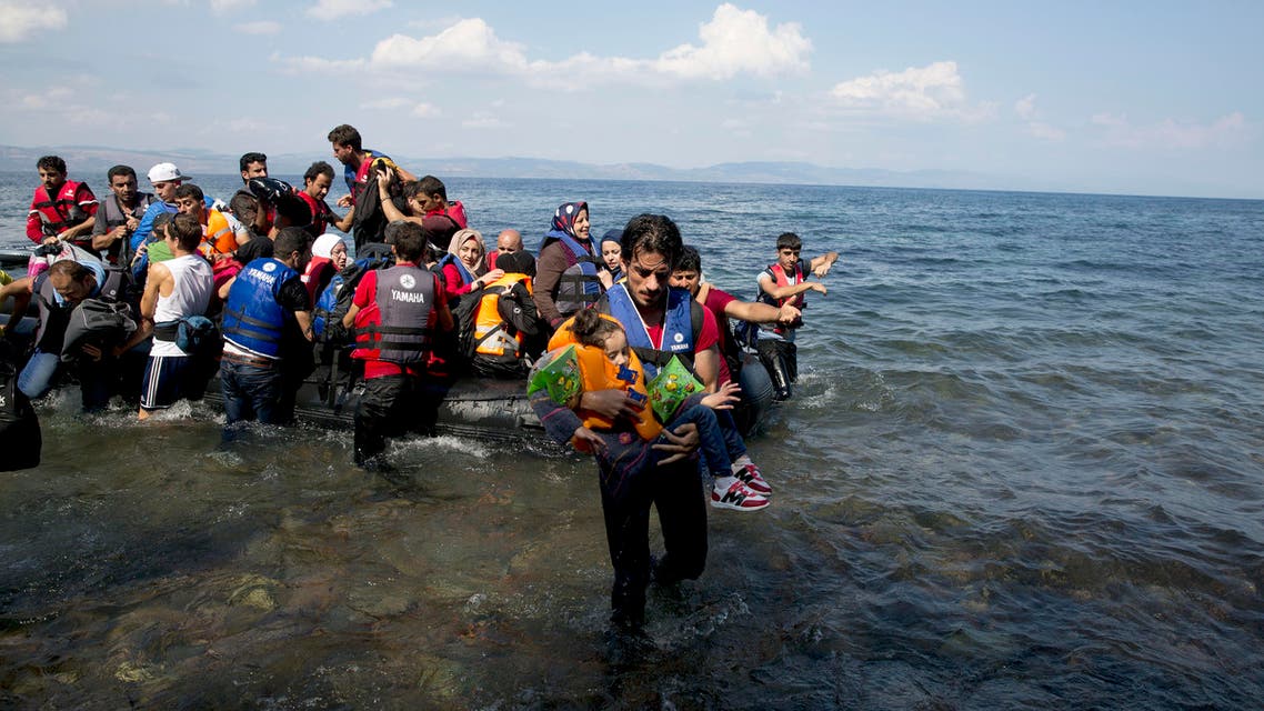 A man carries a child as migrants and refugees arrive on a dinghy after crossing from Turkey to Lesbos island, Greece, Tuesday, Sept. 8, 2015. (File photo: AP)