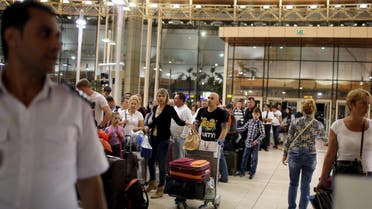A police officer (L) is seen as Russian tourists leave the country after their vacations, at the airport of the Red Sea resort of Sharm el-Sheikh, Egypt November 6, 2015. The head of Russia's Tour Operators' Association says there has been a drop in sales for Egypt holidays after a Russian-operated airliner crashed in Sinai, but says many are still willing to travel. REUTERS/Asmaa Waguih