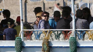 Western tourists peer out of a traditional ferry as they cross to visit the Valley of the Kings in Luxor, Egypt, Thursday, Nov. 5, 2015. 