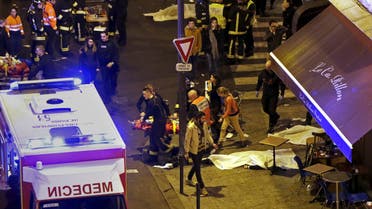 General view of the scene with rescue service personnel working near covered bodies outside a restaurant following shooting incidents in Paris, France, November 13, 2015.