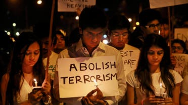  India students hold placards and candles as they observe two minutes silence during a candle march in memory of Pakistani victims killed in a Taliban attack on a military-run school in Peshawar, in Mumbai, India, Monday, Dec. 22, 2014. Seven Taliban gunmen wearing explosives belts stunned the world by storming into the military run school and slaughtering more than 140 people, most of them students. (AP Photo/Rafiq Maqbool)