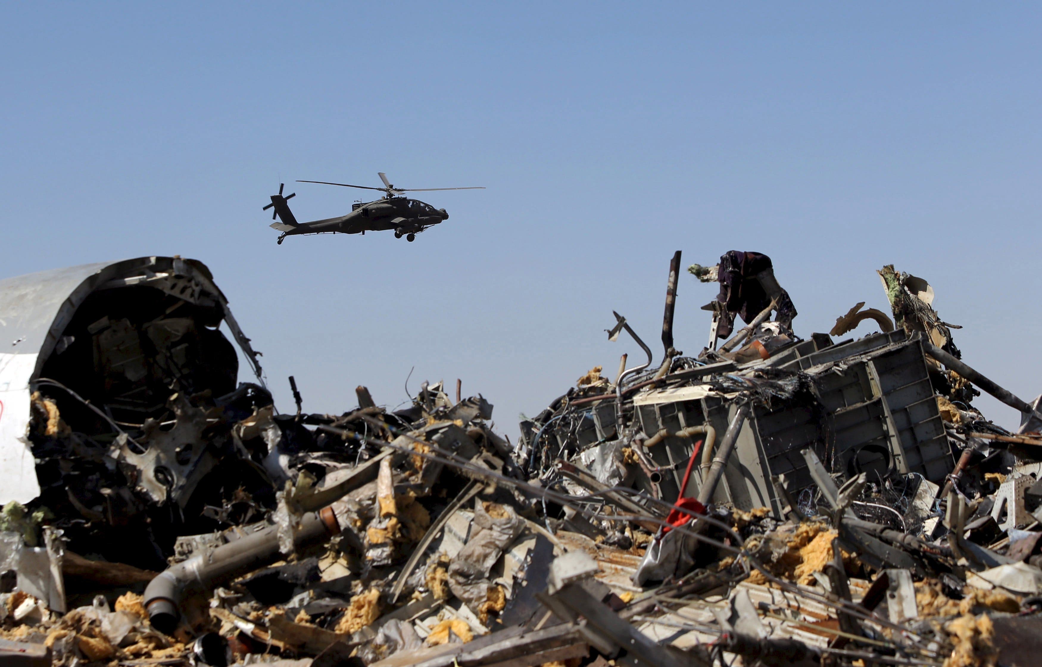 File photo shows an Egyptian military helicopter flying over debris from a Russian airliner which crashed at the Hassana area in Arish city
