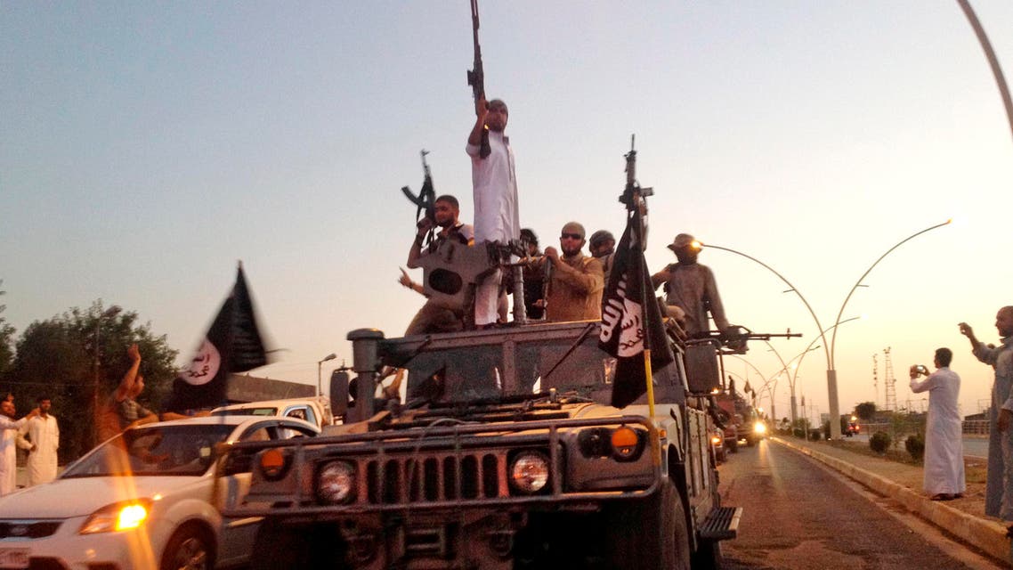 FILE - In this Monday, June 23, 2014 photo, fighters from the Islamic State group parade in a commandeered Iraqi security forces armored vehicle down a main road at the northern city of Mosul, Iraq. (AP Photo, File)