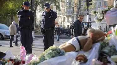 Policemen read messages which left at a makeshift memorial next to the Bataclan concert hall in Paris, France, Wednesday, Nov. 18, 2015. AP 