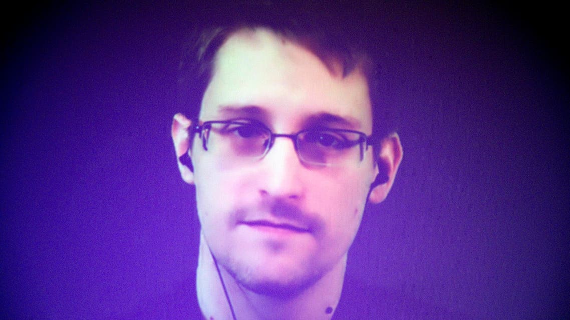  Former U.S. National Security Agency contractor Edward Snowden, who is in Moscow, is seen on a giant screen during a live video conference for an interview as part of Amnesty International's annual Write for Rights campaign at the Gaite Lyrique in Paris, France, Dec. 10, 2014. (AP Photo/Charles Platiau, Pool)