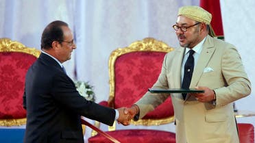 Morocco's King Mohammed VI, right, shakes hands with French President Francois Hollande following the signing of a convention between the two counties in the Moroccan port city of Tangiers, Sunday, Sept. 20, 2015. (AP)