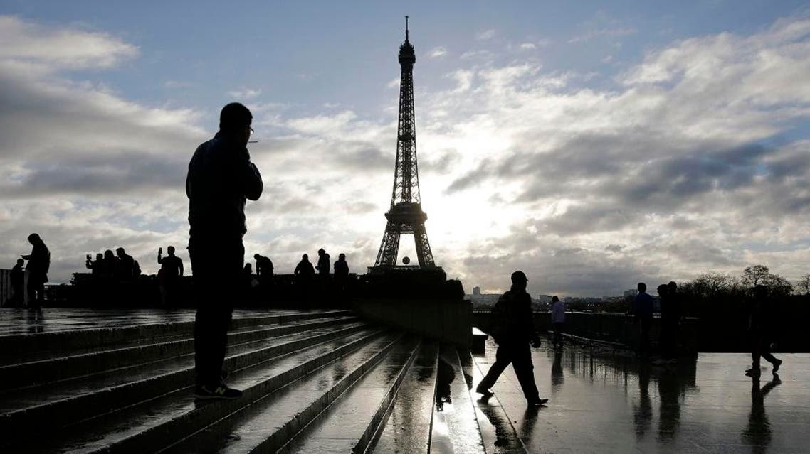 A man looks at the Eiffel tower from the Trocadero place a week after the start of the Paris attacks, in Paris, Saturday, Nov. 21, 2015. French President Francois Hollande will preside over a national ceremony on Nov. 27 honoring the victims of the deadliest attacks on France in decades. (AP Photo/Laurent Cipriani)