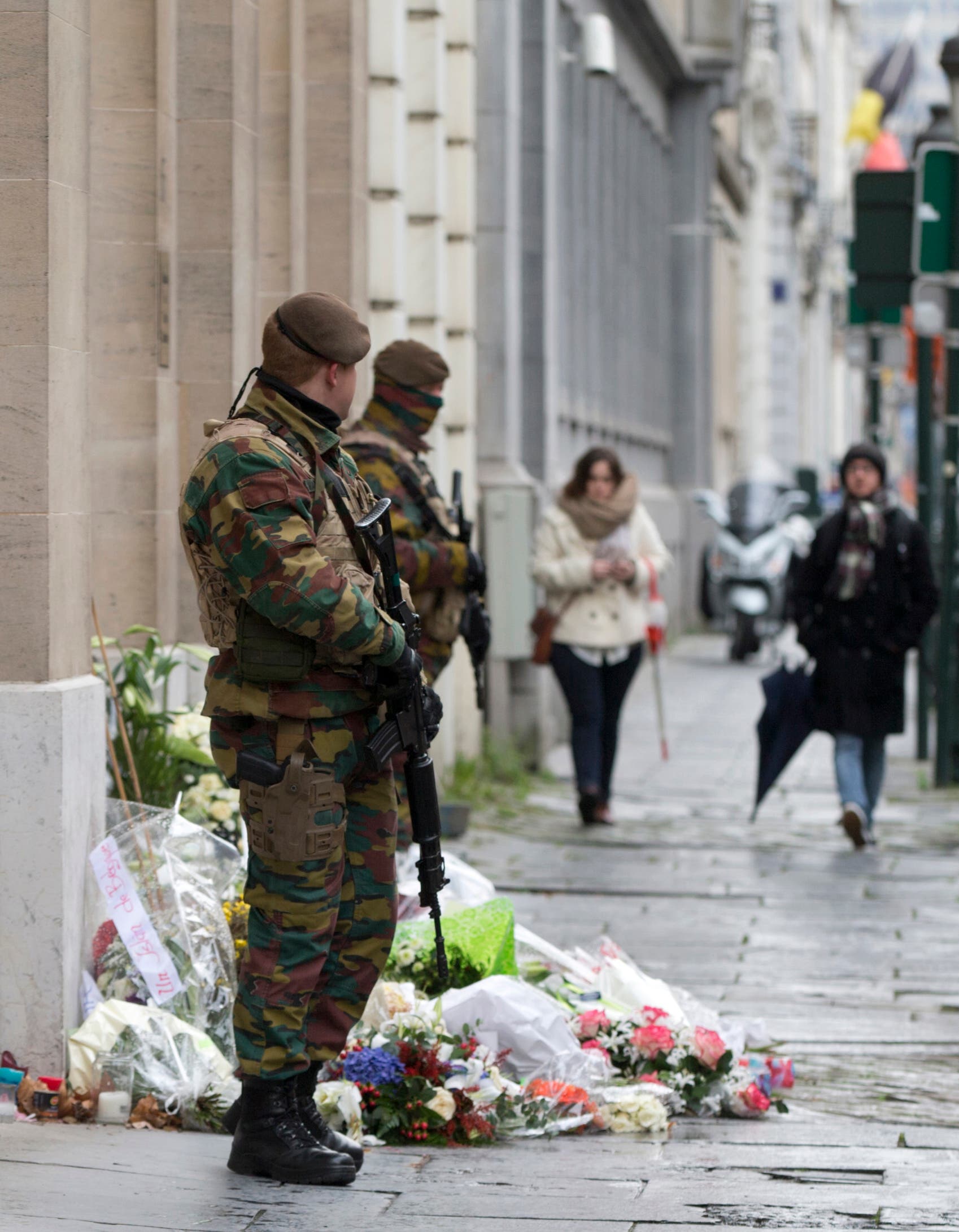 Belgian Army soldiers patrol next to flowers left outside of the French Consulates office in Brussels Saturday, Nov. 21, 2015. (AP)