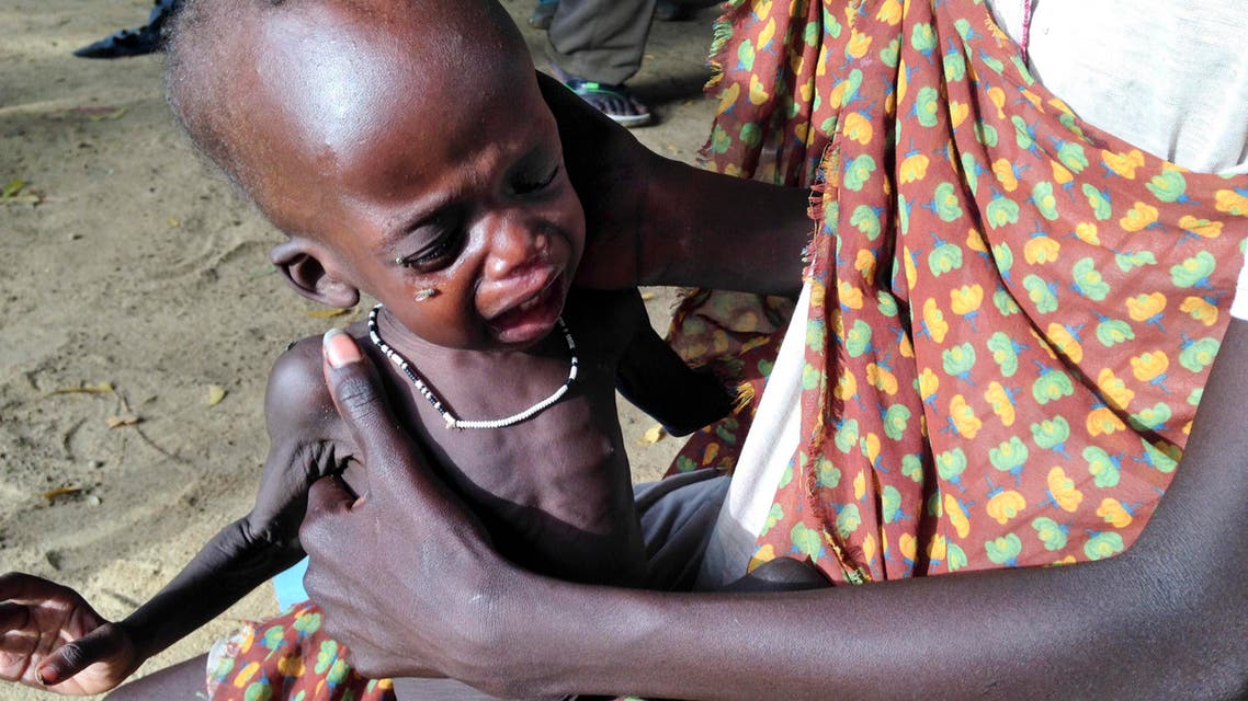 In this photo taken Friday, May 9, 2014 and made available Tuesday, May, 13, 2014, a mother holds her malnourished child at a hospital run by Medecins Sans Frontieres (Doctors Without Borders) in Leer, in oil-rich Unity State, South Sudan. Bodies stuffed in wells. Houses burned down. Children playing on military hardware. And young infants showing the skeletal outlines of severe hunger. These are the scenes from a remote part of South Sudan _ Leer _ where the aid group Doctors Without Borders has just begun feeding severely malnourished children about three months after the group’s hospital was destroyed in violence that has been ripping apart the country since December. (AP Photo/Josphat Kasire)