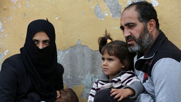  In this picture taken on Friday, Oct. 23, 2015, Syrian refugee Anwar Ahmad Abdullah, 42, who fled from the central Syrian town of Palmyra from the Russian airstrikes, holds his daughter Yara, 3, as he sits next to his wife Hind, left, during an interview with The Associated Press at their unfurnished home, in the Turkish-Syrian border city of Reyhanli, southern Turkey. "We had no intention to leave our country at all. But the Russian airstrikes made us leave Syria," Abdullah's wife, Hind, said as her 10-month-old son Abdul-Muneim slept in her lap. She said Russian bombing was more intense and destructive than government strikes. (AP Photo/Hussein Malla)